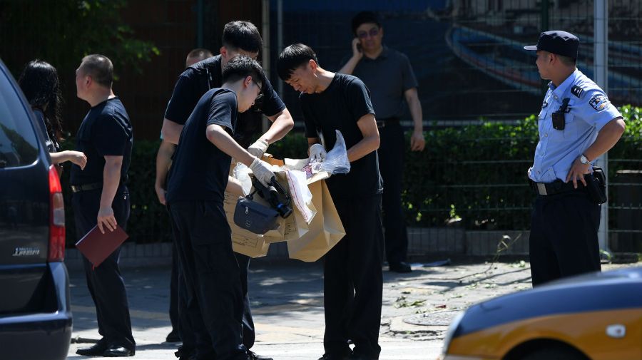 Oficiales chinos, trabajando en la investigación de la explosión en la embajada estadounidense en Pekín.