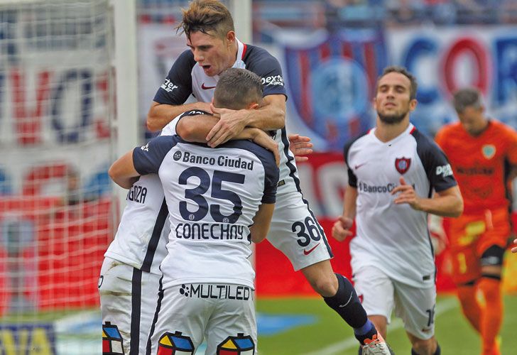 Todos con Ortigoza. El autor del gol recibe los abrazos sus compañeros. El Ciclón sigue en carrera.