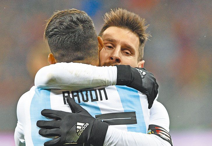 Abrazo de socios. Messi abraza y festeja junto a Pavón, que le sirvió el gol a Agüero en el final del partido contra los rusos.