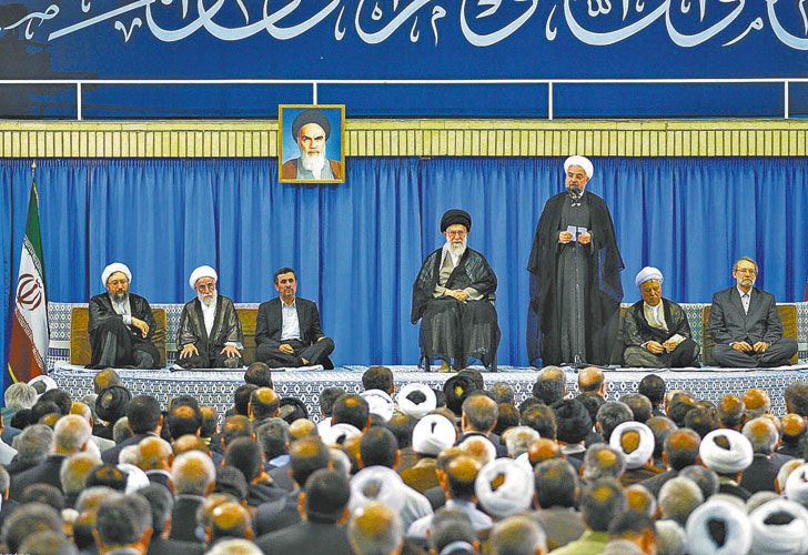 Dos hombres en pugna. Alí Jamenei (sentado al centro) y Hasan Rohani (de pie) evidenciaron su discrepancia sobre las manifestaciones. Estilos contrapuestos.