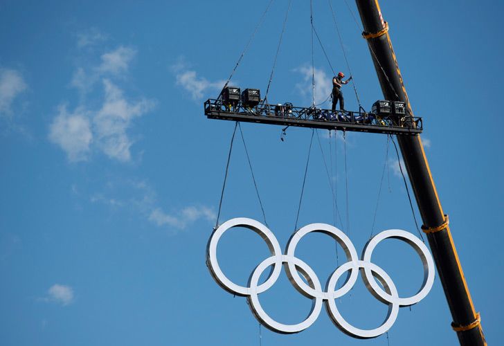 the olympic rings are craned into position at the obelisk, ahead