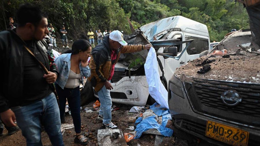 Buscan a las víctimas entre los restos de los vehículos impactados por el cilindro bomba en Cajibío, Colombia. 