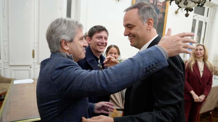El ministro de Economía, Luis Caputo, saluda al jefe de Gabinete, Manuel Adorni, ante la sonrisa del asesor presidencial Santiago Caputo. 