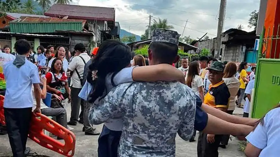 Un soldado rescata a una niña afectada por el terremoto en el sur de Filipinas.