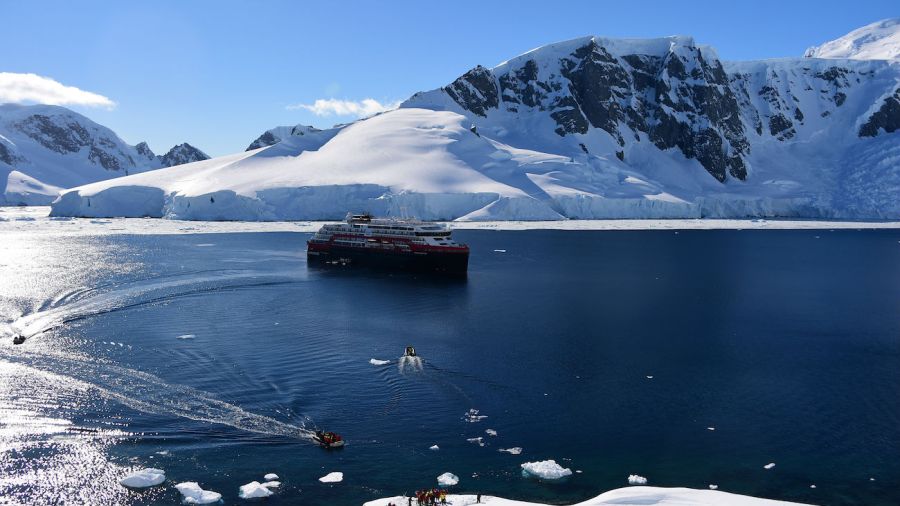 Cruise ship and tourists landing in antarctica stock