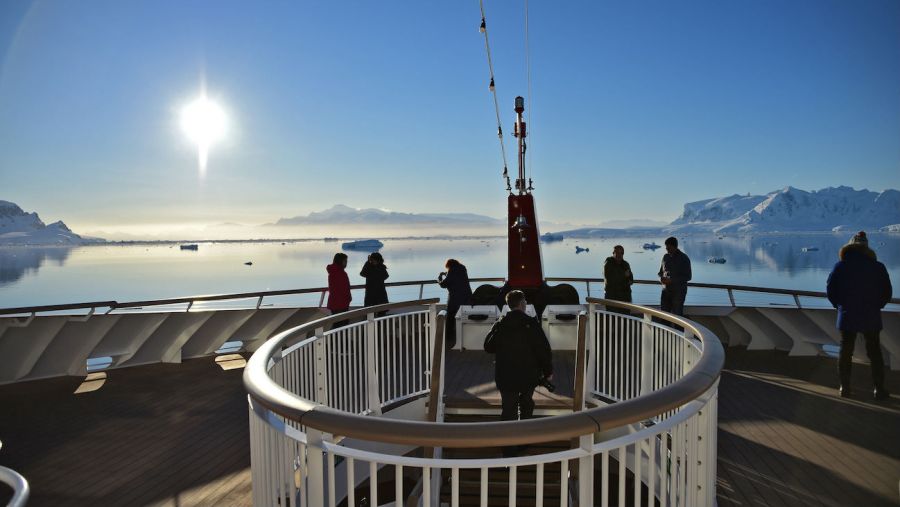 Tourists watch sunset on boat in Antarctica stock 