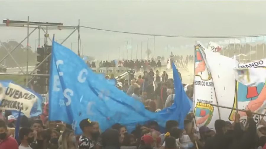 De fondo, grupos de los militantes que habían llegado al acto de la Ruta 3, arriando las banderas y abandonando el lugar por el viento.