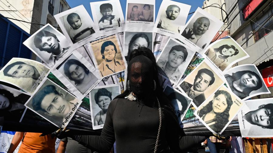 Fotogaleria Un activista sostiene fotos de víctimas de la guerra civil para protestar contra el gobierno del presidente Nayib Bukele, en San Salvador