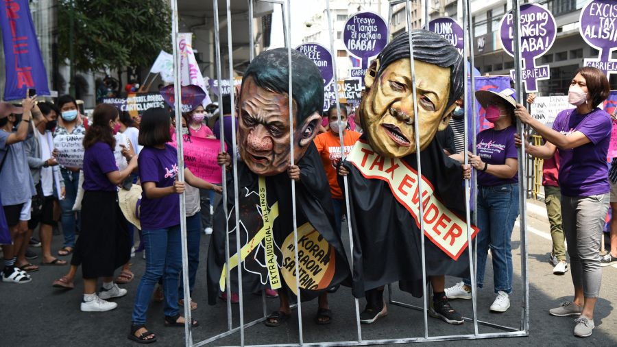 Fotogaleria Manila Mujeres activistas sostienen una celda improvisada con colegas que llevan máscaras que representan al presidente Rodrigo Duterte y a Bongbong Marcos, hijo del difunto dictador Ferdinand Marcos