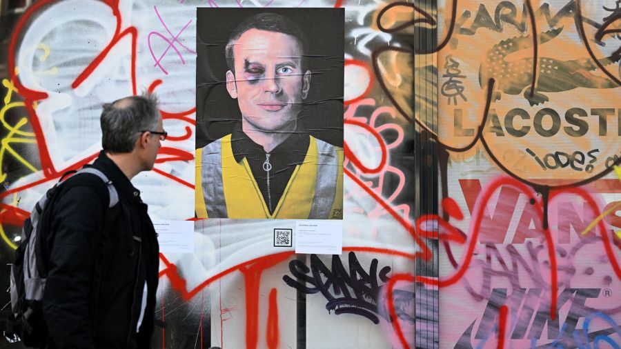 Fotogaleria Un hombre pasa junto a un cartel que representa a un magullado presidente francés Emmanuel Macron en París