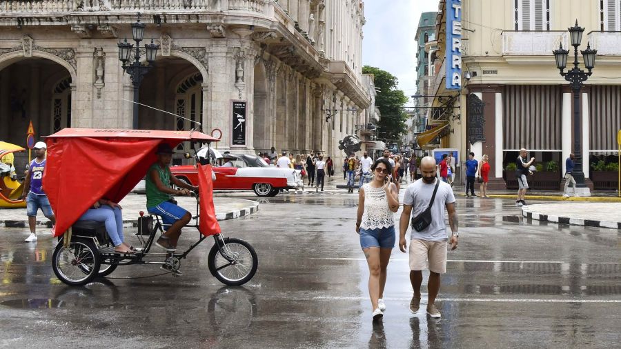 Fotogaleria Personas cruzan una calle, en La Habana, capital de Cuba