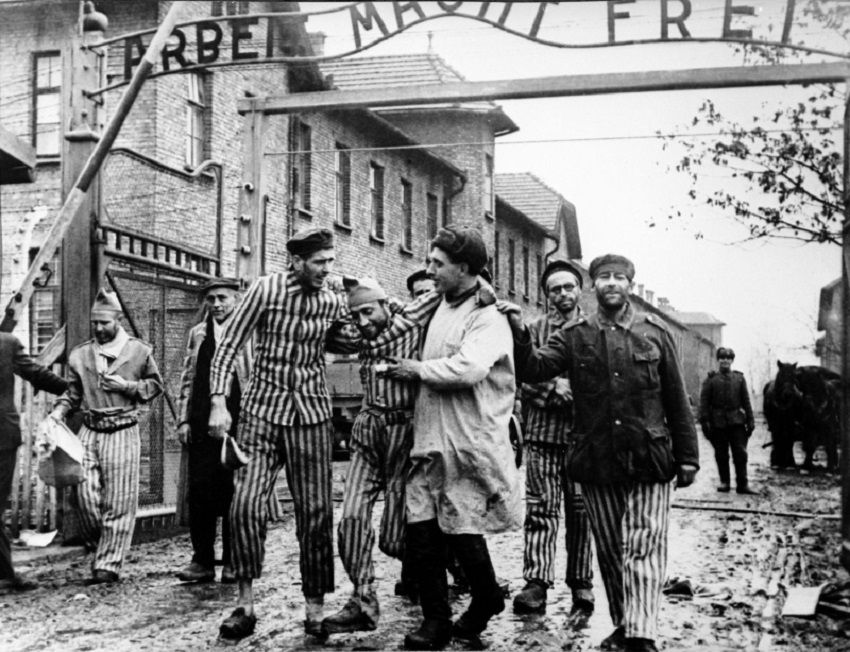Supervivientes de Auschwitz caminan junto a un doctor de la Cruz Roja el día de la liberación del campo de exterminio en 1945. 