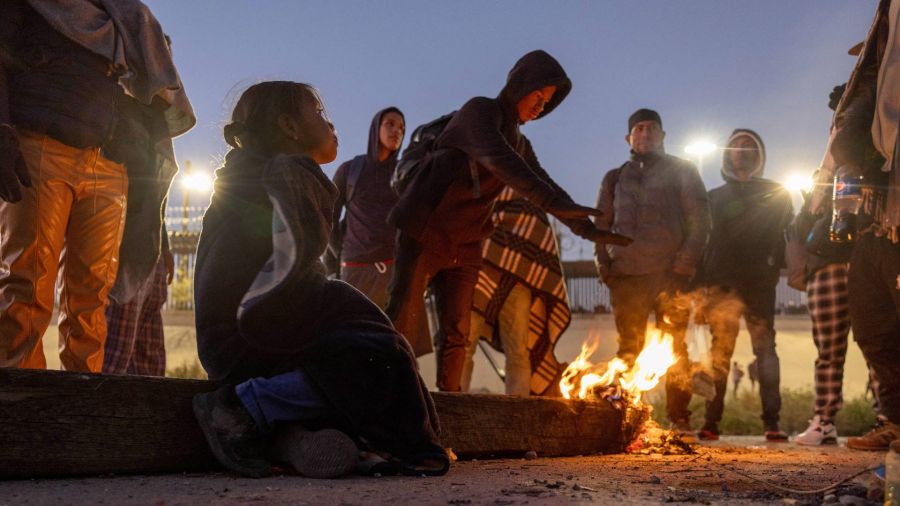 Fotogaleria Migrantes, entre ellos Blaidimar, de 8 años, de Venezuela, se calientan junto a una fogata frente a la valla fronteriza entre Estados Unidos y México