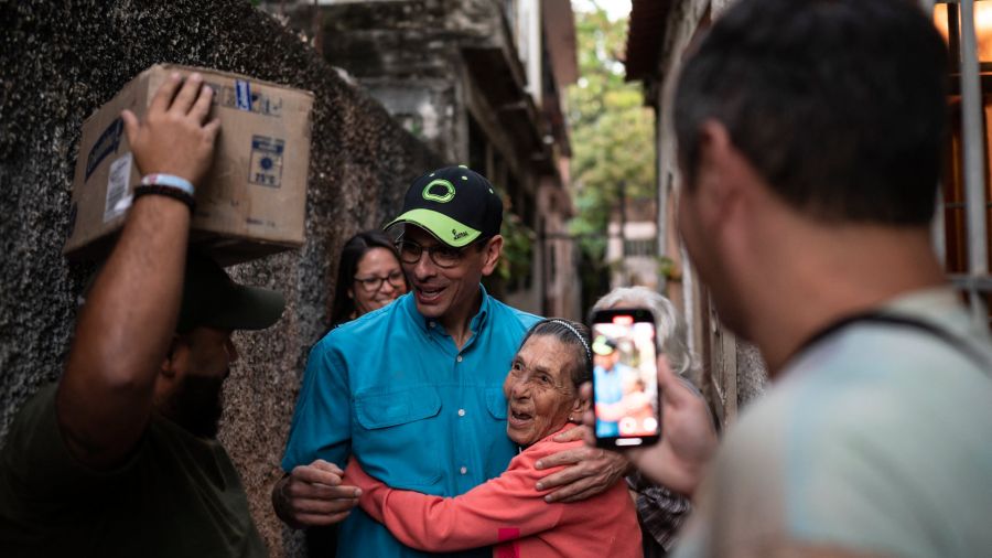Fotogaleria El líder de la oposición venezolana, Henrique Capriles, abraza a un simpatizante mientras camina por las calles como parte de una campaña para entregar medicinas a adultos mayores en Guarenas, Venezuela