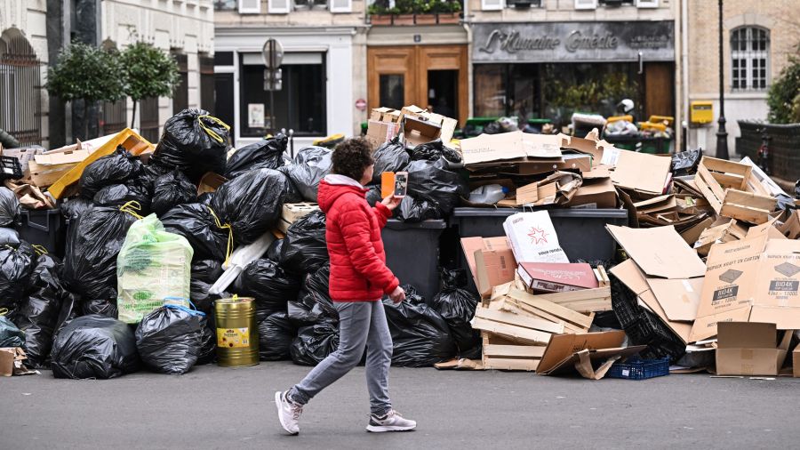 Fotogaleria Un peatón pasa junto a contenedores de basura doméstica en una calle de París, que se han ido acumulando desde que los recolectores se declararon en huelga