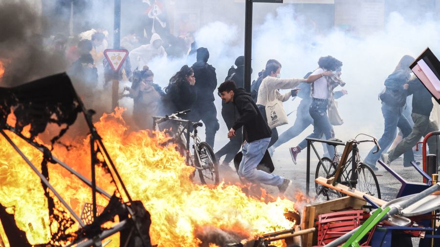 Fotogaleria Manifestantes corren entre el humo de gases lacrimógenos junto a una hoguera callejera durante una manifestación en el marco de una jornada nacional de huelgas y protestas en Francia