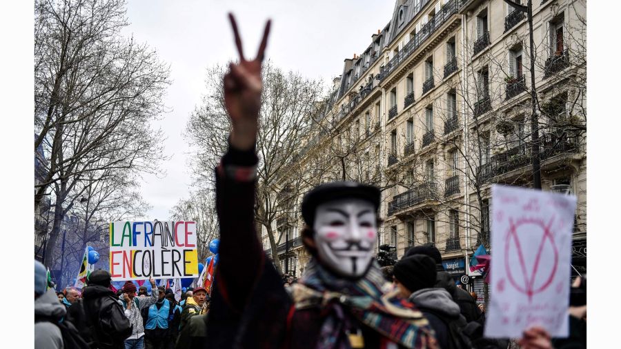 Fotogaleria Un manifestante sostiene una pancarta en la que se lee Francia en cólera mientras otro con una máscara de Guy Fawkes hace el gesto de la V durante una manifestación