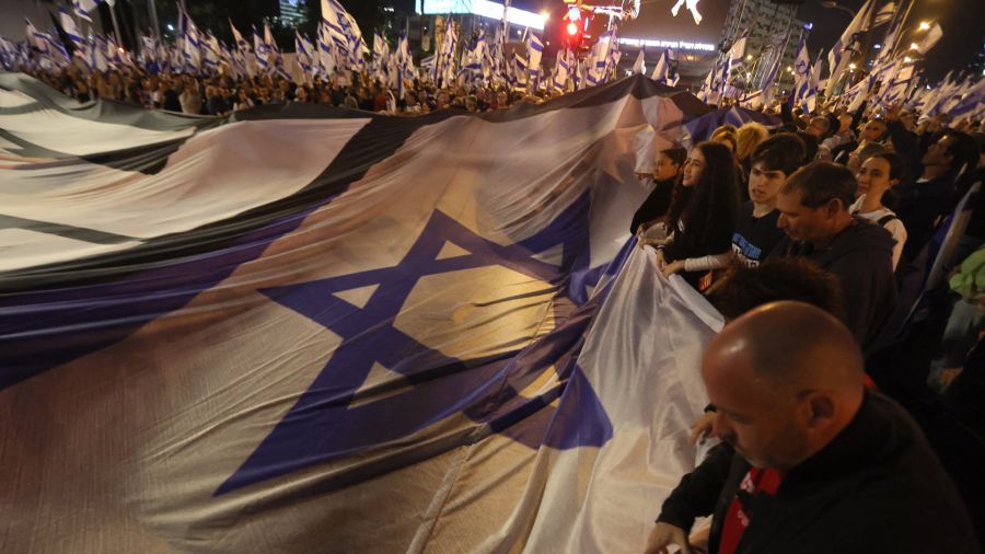 Fotogaleria Manifestantes levantan una gran bandera nacional durante una concentración para protestar contra el proyecto de ley de reforma judicial del gobierno israelí en Tel Aviv