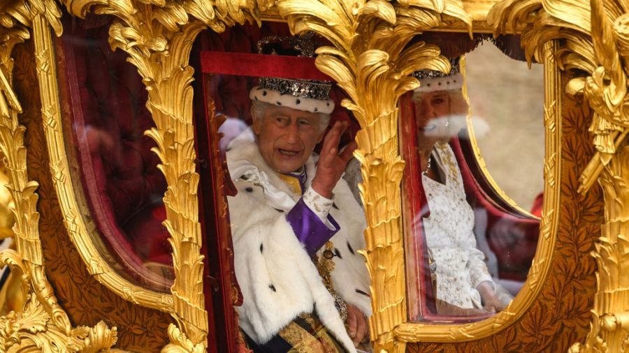 Carlos III y Camilla saludan desde la carroza, luego de su coronación.