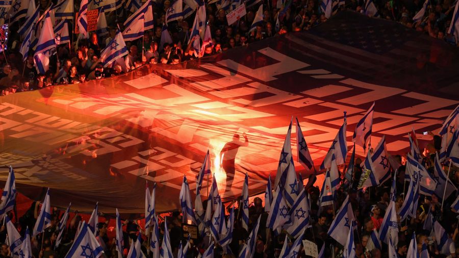 Fotogaleria Manifestantes levantan una gran pancarta durante una concentración de protesta contra el proyecto de ley de reforma judicial del gobierno israelí en Tel Aviv