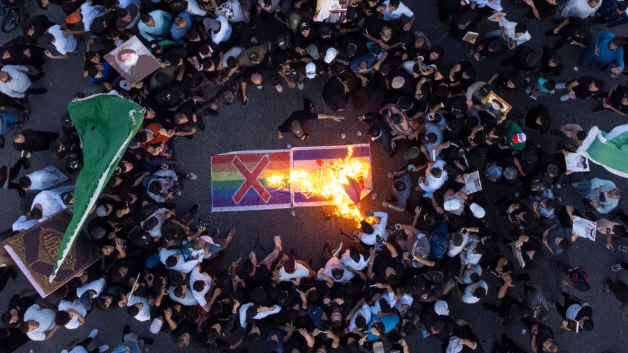 Fotogaleria Simpatizantes del movimiento sadrista iraquí queman una bandera israelí y una bandera arco iris durante una manifestación en Basora, en medio de las protestas contra la quema de un Corán