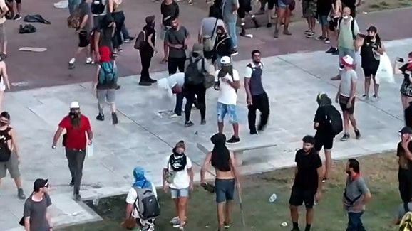 Manifestantes rompen baldosas en Plaza Congreso para lanzarlas a la policía.