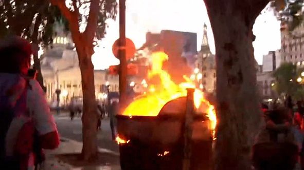 Un contenedor de basura incendiado por los manifestantes más violentas en Congreso.