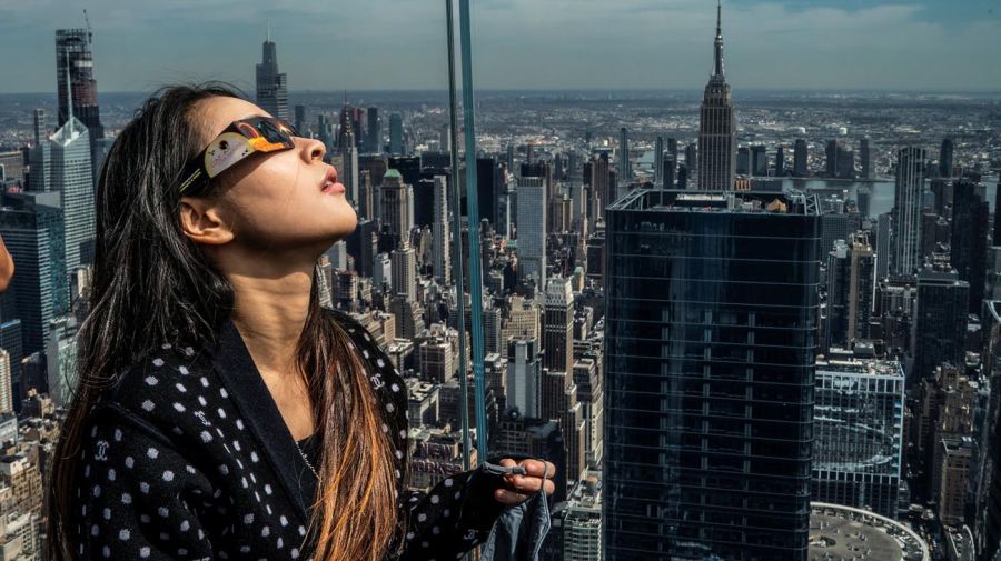 Varias personas se reúnen para ver un eclipse solar parcial, en el que la luna tapará parcialmente el sol, en Times Square, Nueva York