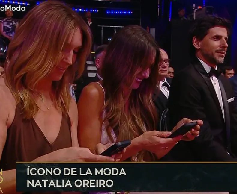 Pampita mira su celular mientras Oreiro es premiada