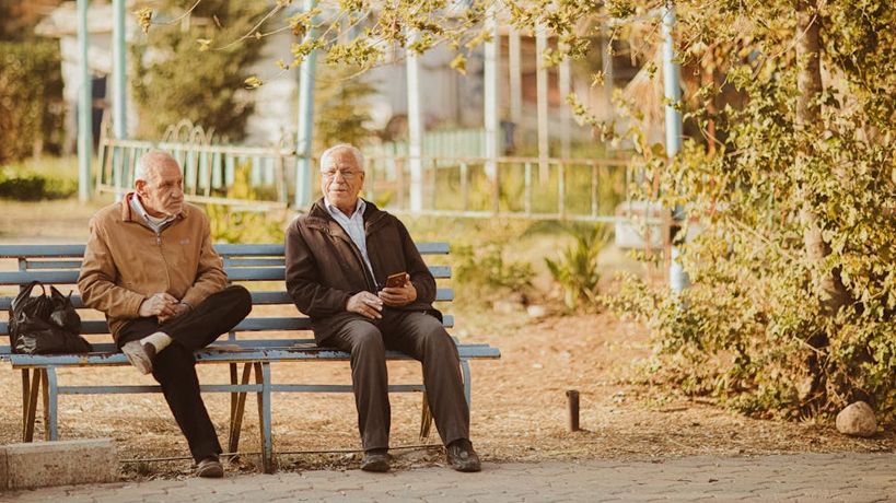 Ancianos sentados en un banco de la plaza