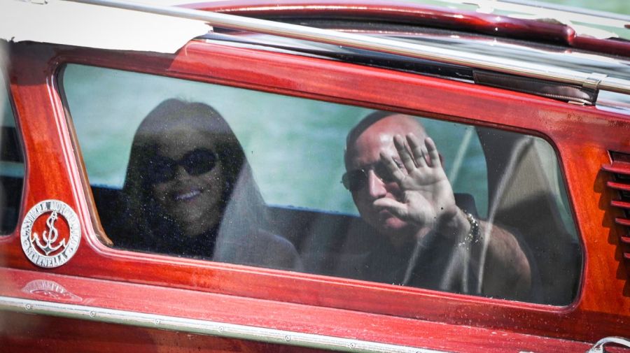 El fundador de Amazon, Jeff Bezos, y Lauren Sánchez saludan desde el taxi acuático al llegar al Hotel Aman el 25 de junio de 2025