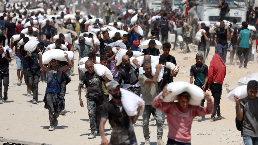 Fotogaleria Imagen de palestinos cargando sacos de harina después de que la ayuda humanitaria entrara en Gaza a través de un paso fronterizo, en Beit Lahia, en el norte de la Franja de Gaza.