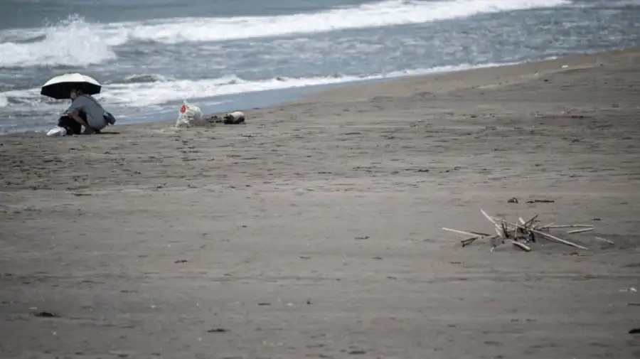 Una persona descansa en la playa de Heisaura después del aviso de tsunami