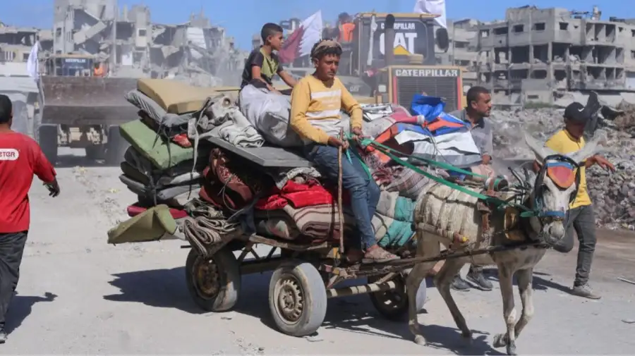 Personas desplazadas en Gaza transportan sus pertenencias en un carro tirado por burros