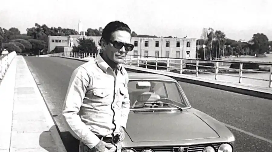 Pier Paolo Pasolini junto al Alfa Romeo azul en el cual sería asesinado