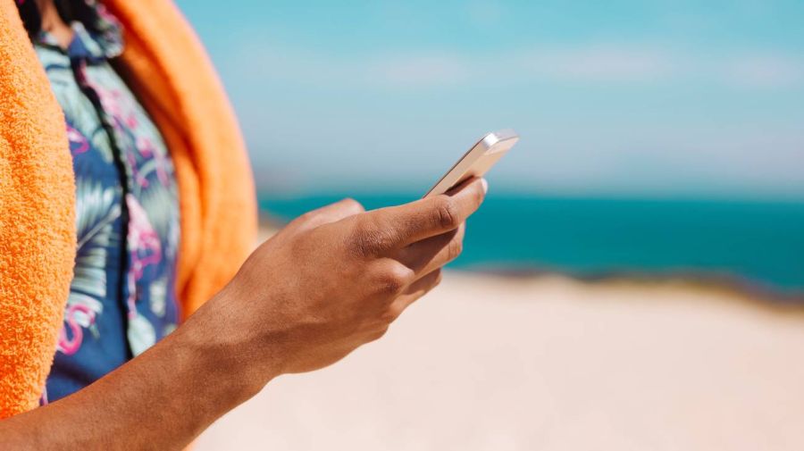 Con celular en la playa 07022026