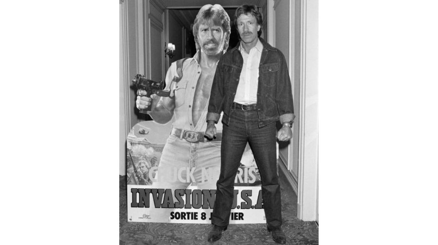 Chuck Norris posa el 27 de noviembre de 1985 frente al cartel de la película 'Invasion USA' en París