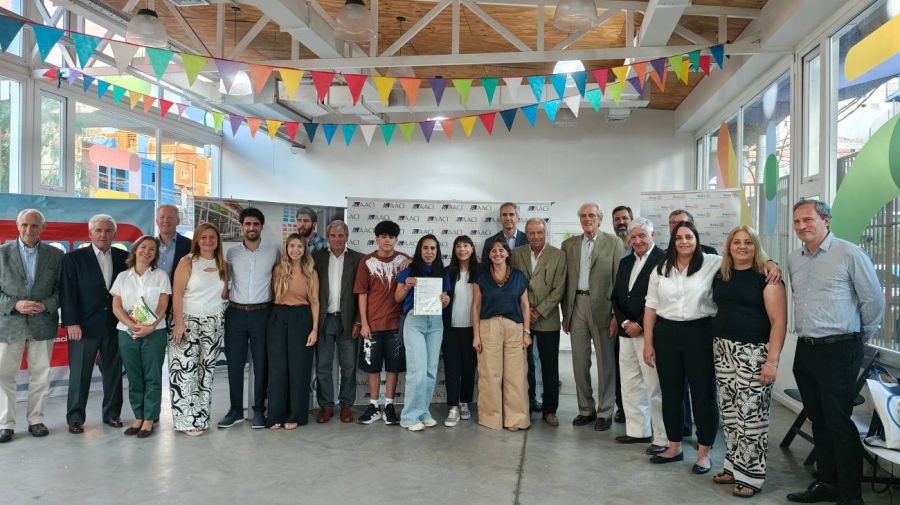 Miguel Maxwell y Josefina Rouillet con el alumno y su mamá al recibir su diploma este lunes en el Centro Comunitario Bajo Autopista.
