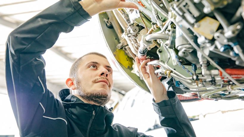 Mecánico arregla motor de avión