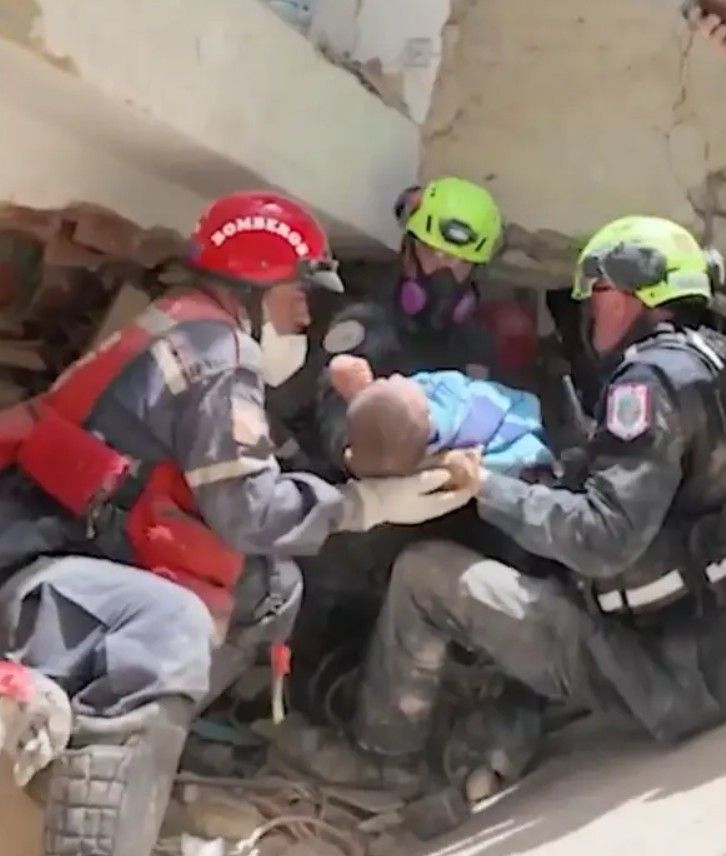 Los equipos de rescate estadounidenses sacan a una bebé de 9 meses de entre los restos de un edificio derrumbado tras los potentes terremotos que azotaron Venezuela