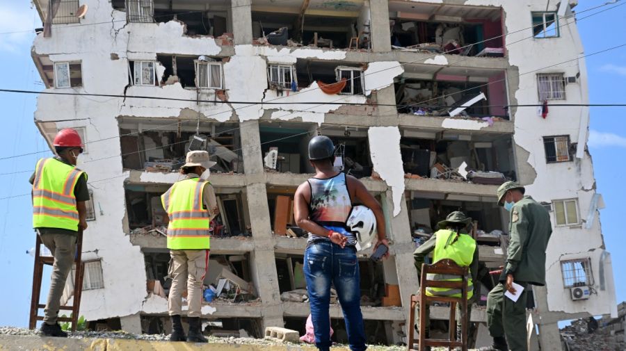 Miembros de las Fuerzas Armadas de Venezuela, un rescatista y un residente posan junto a un edificio de apartamentos gravemente dañado en Catia La Mar, Venezuela, el 16 de julio de 2026