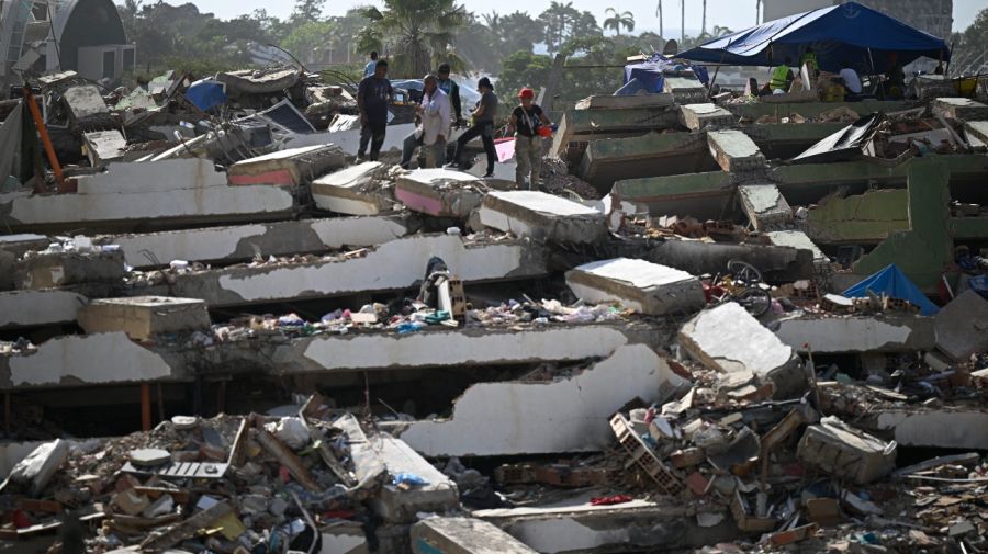 Varias personas se encuentran entre los escombros mientras buscan cuerpos en el lugar donde se derrumbaron varios edificios en Caraballeda, estado de La Guaira, Venezuela, el 16 de julio de 2026