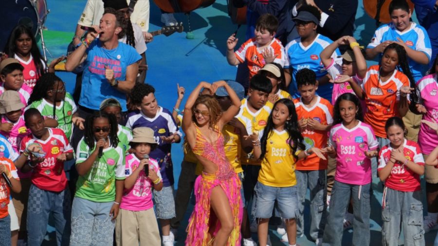 El cantante de Coldplay, Chris Martin (arriba a la izquierda), la cantante colombiana Shakira (en el centro, al frente) y unos niños actúan durante el espectáculo del medio tiempo de la final del Mundial de fútbol de 2026