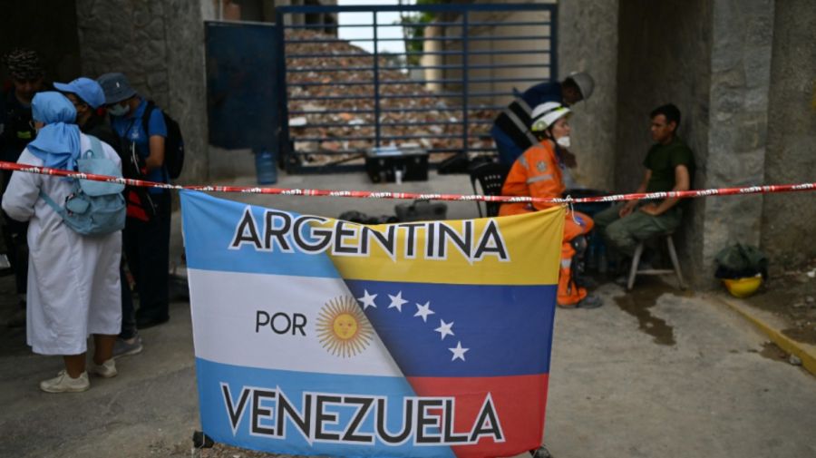 banderas de Argentina y Venezuela entrelazadas frente a las ruinas de edificios derrumbados en Punta Tanaguanera, La Guaira, Venezuela, el 21 de julio de 2026