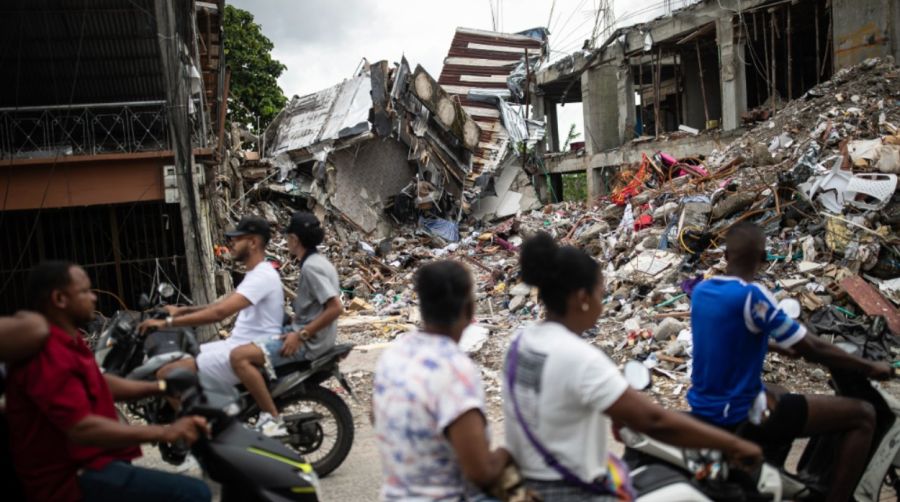 Personas en motocicletas pasan frente a un edificio destruido en el barrio de Medrano, en Quibdó, departamento del Chocó, Colombia, el 15 de agosto de 2026, días después de un terremoto de magnitud 7,4