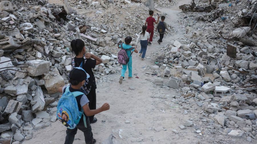 Fotogaleria Niños palestinos caminan hacia la escuela entre los escombros de edificios destruidos al comenzar el año escolar en Jan Yunis, en el sur de la Franja de Gaza