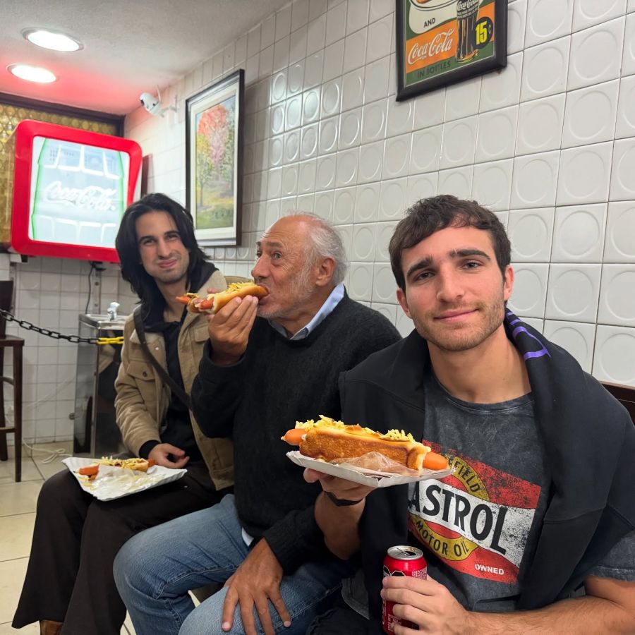 Valentín Yan junto a su abuelo y su hermano comiendo panchos