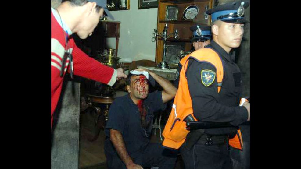 Un trabajador con la cabeza sangrante espera la llegada de una ambulancia del SAME.