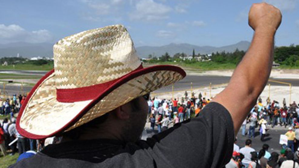 Miles de manifestantes esperan a Zelaya en el aeropuerto de Tegucigalpa.