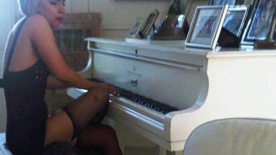 Lady GaGa sentada al piano de Lennon